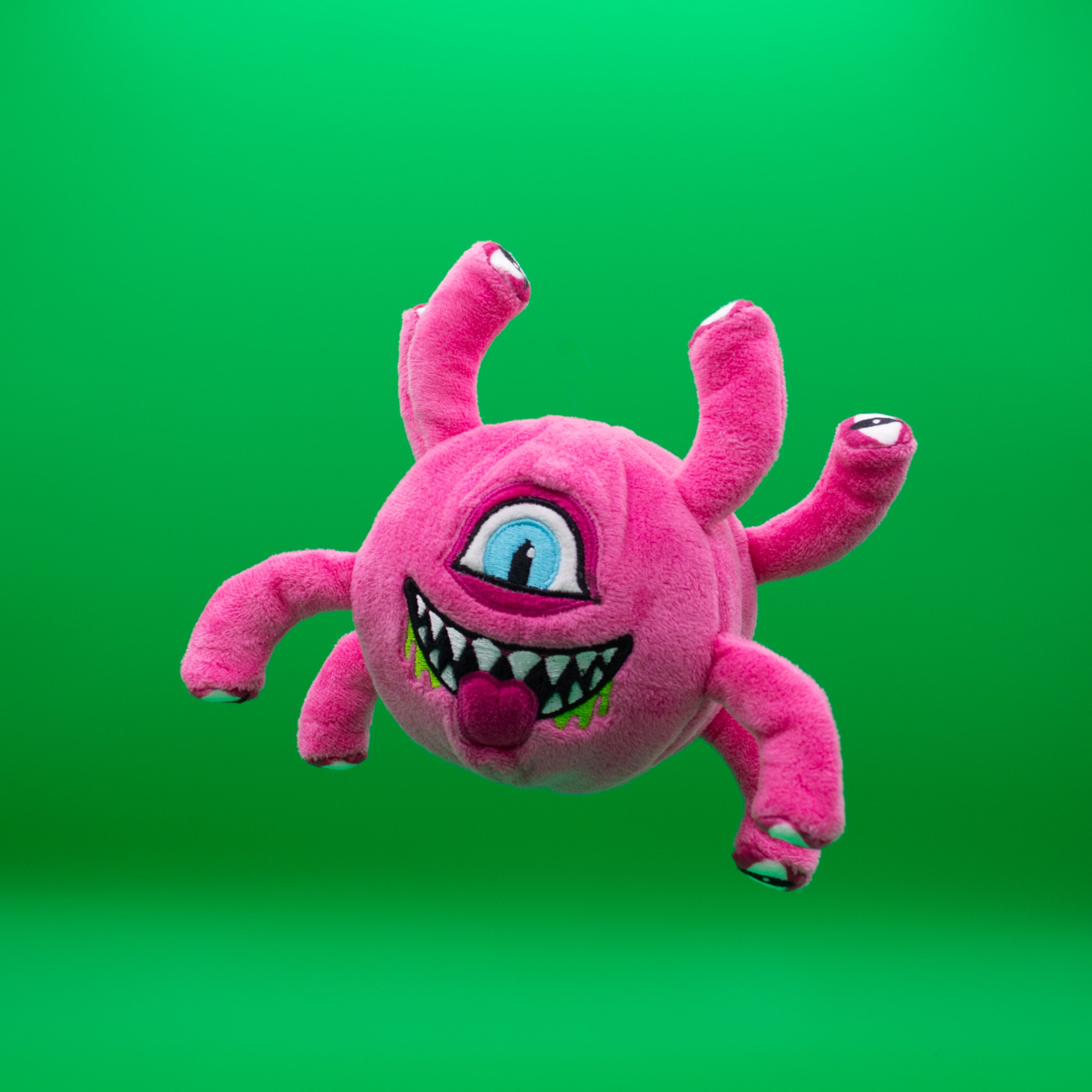 Pink Eye Beast 3-in-1 Plush Dog Toy with Rubber Ball Core on Green Background - In the Eye of the Beholder Dog Toy