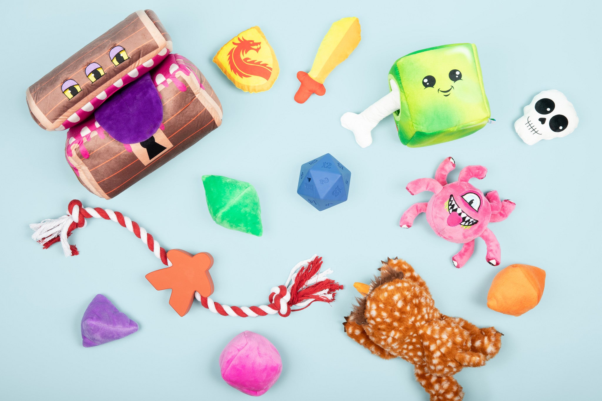 Assortment of TTRPG-inspired dog toys scattered on a light blue background